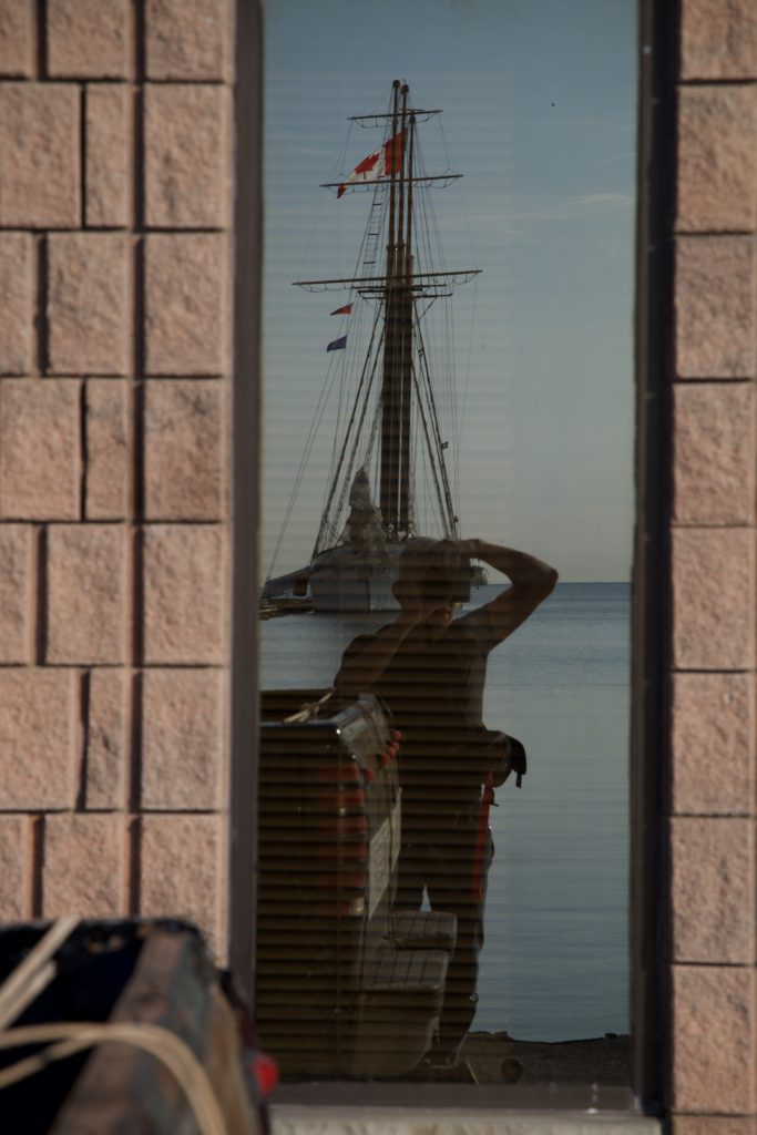self portrait photographer with camera with tall ship in background