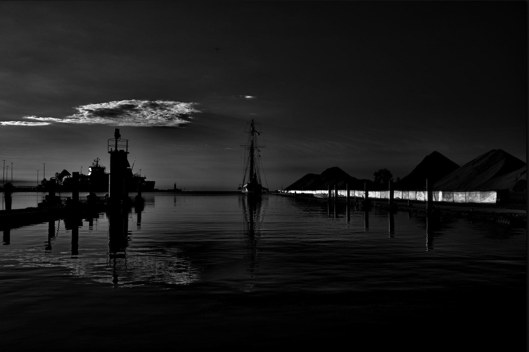 a sailing ship appears as a silhouette