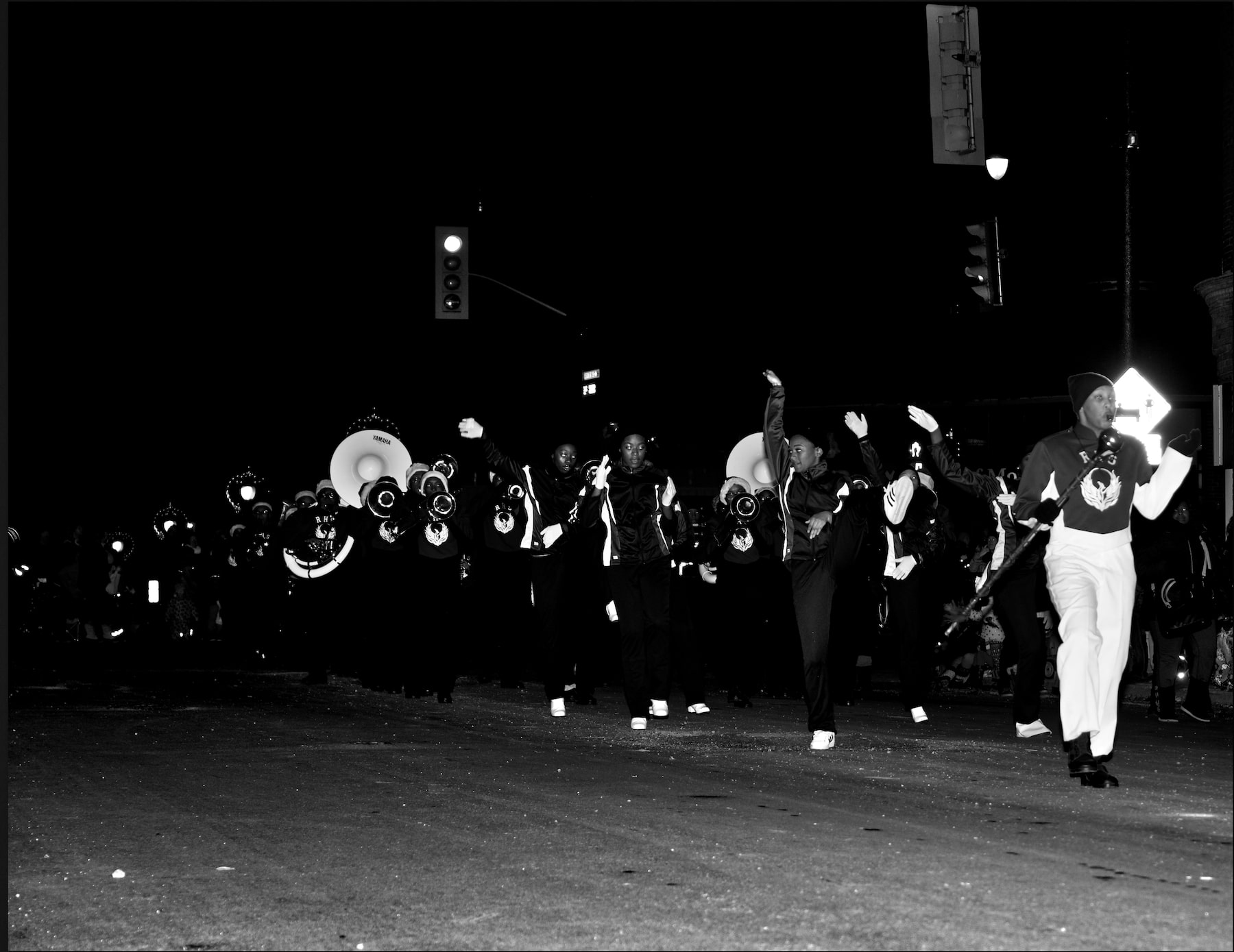 an all African american marching band photographed marching at a parade during the evening