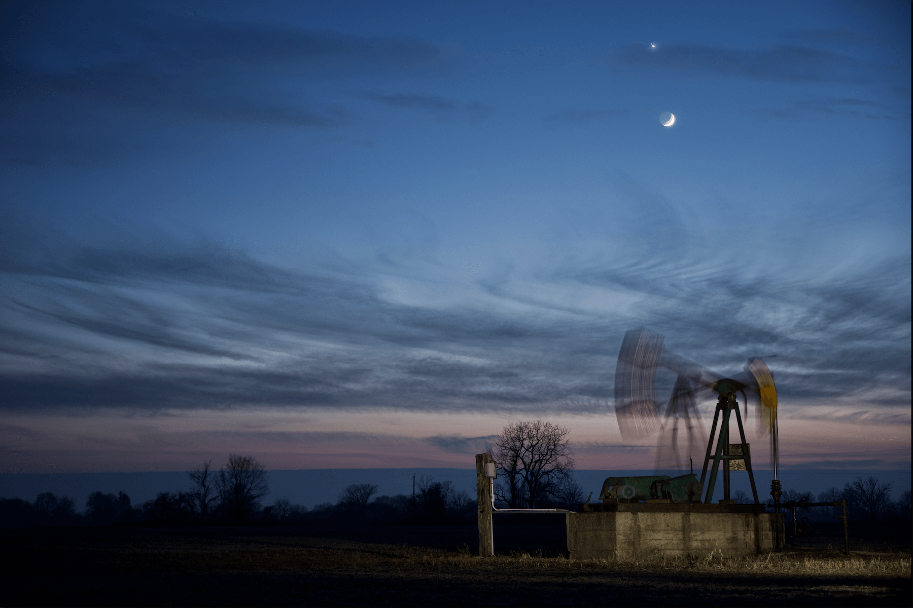 a oil well pump jack blurring action due to time lapse photography