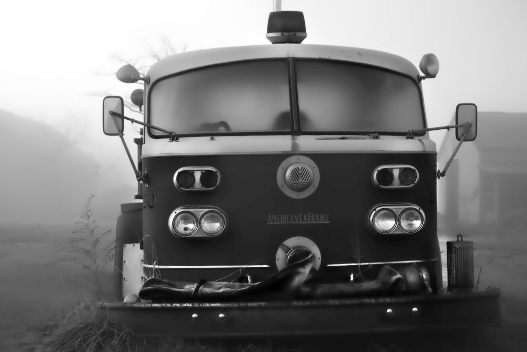 an abandoned fire truck in a foggy farmers field