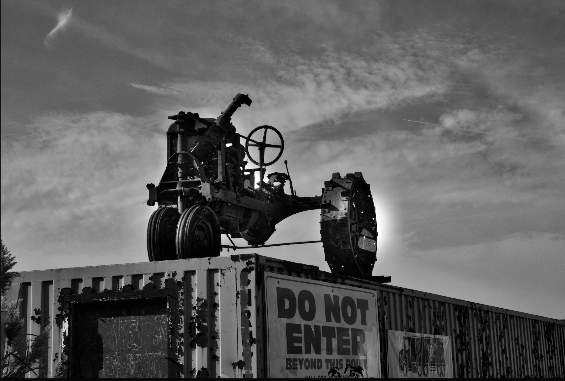 an old tractor on a abandoned shipping container