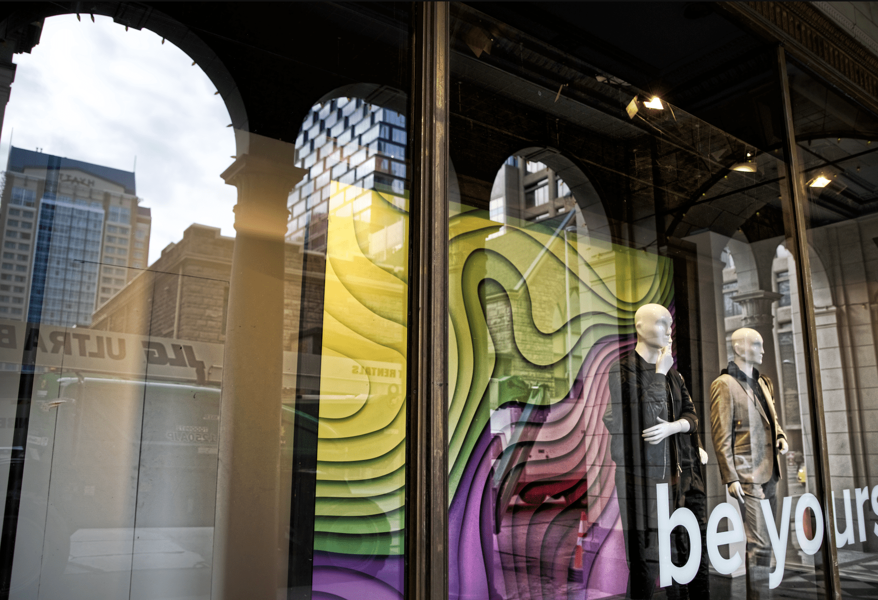 Color photograph of two male mannequins in a store front window