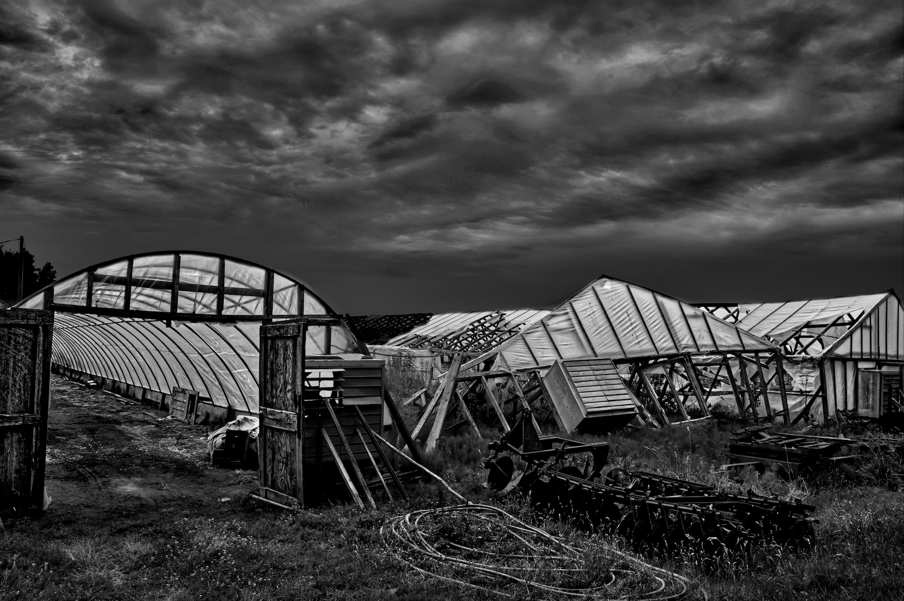 collapsed greenhouses with a angry sky in the background
